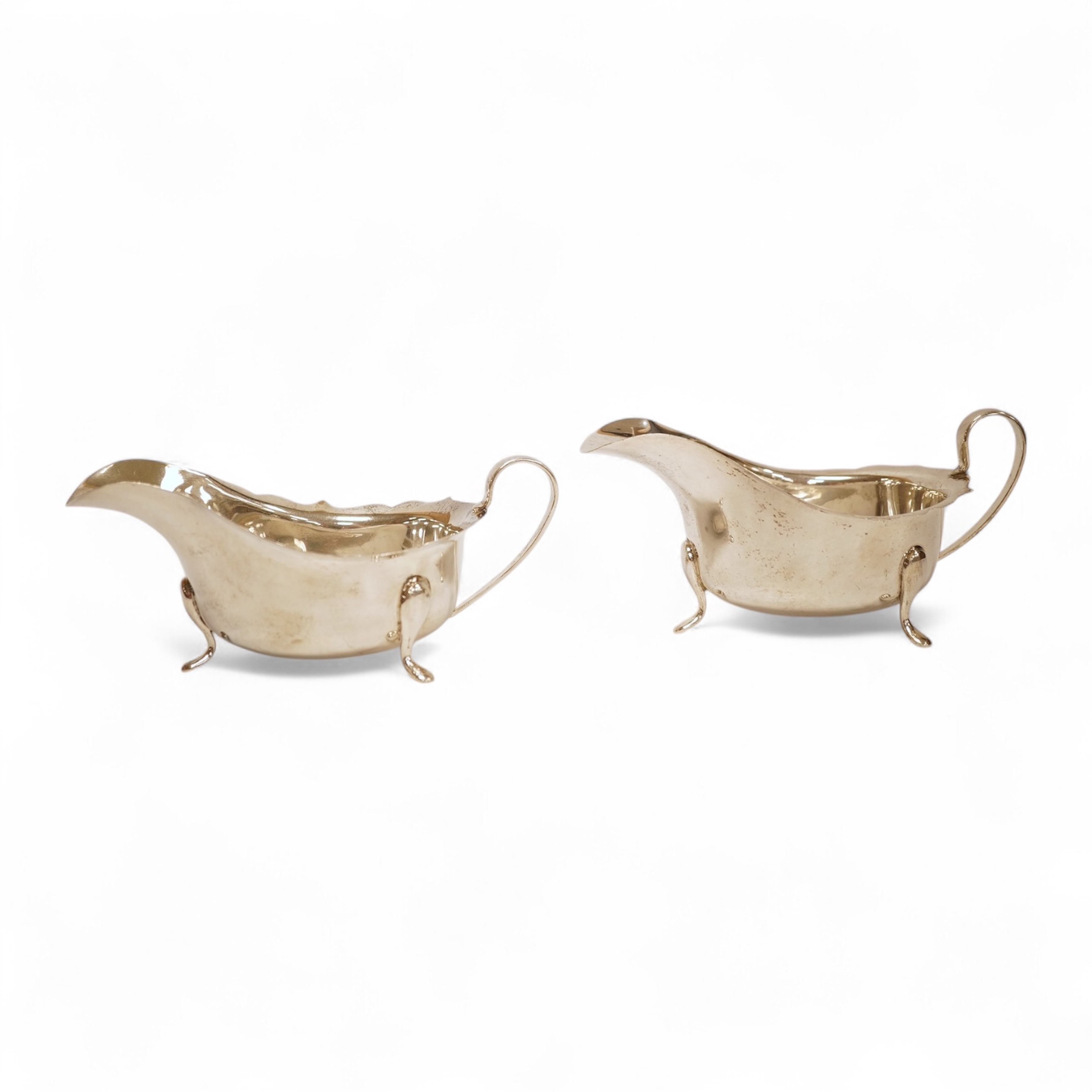 A pair of 1930's silver sauceboats, with cut borders, Barker Brothers Silver Ltd, Birmingham, 1935 and 1938, length 14.6cm, 5.8oz.